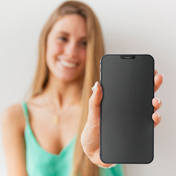 Frau hält ein Smartphone in Richtung Kamera