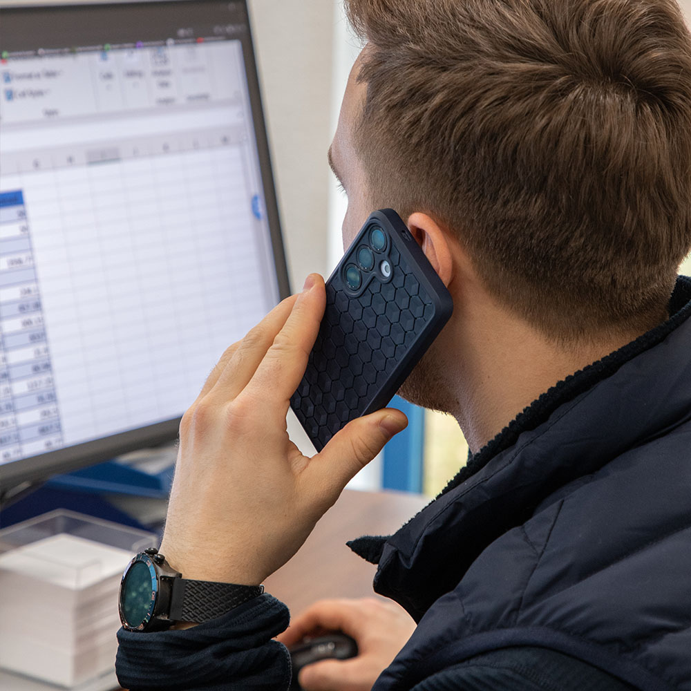 anco_Honeycomb_Case_telefonieren anco® Honeycomb Case in der Hand, Mann sitzt am Schreibtisch und telefoniert